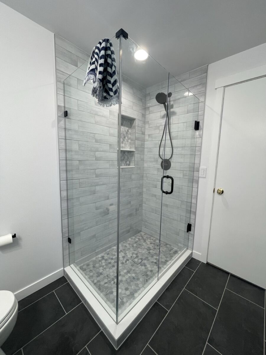 Corner glass shower with a pebble floor