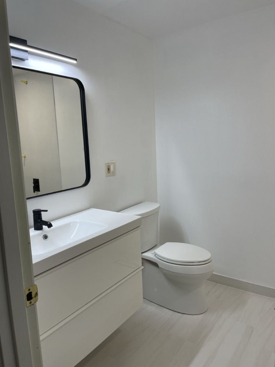 Floating white vanity with black mirror