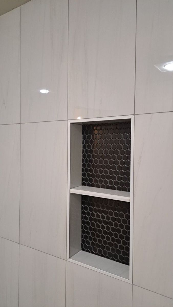 Shower niche with black hexagon mosaic
