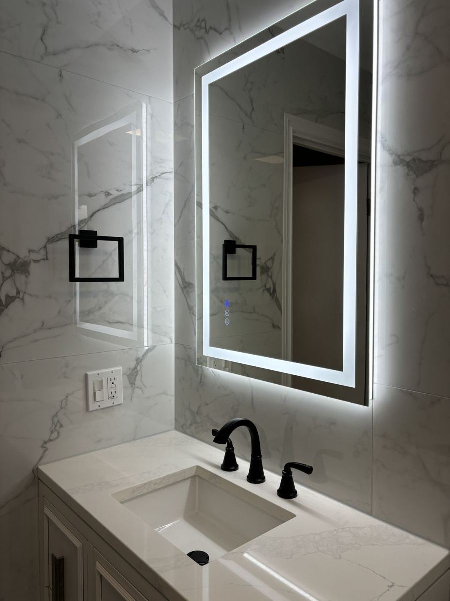 Marble-look tile and lit mirror